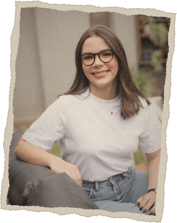 Giovana sorrindo, de óculos e camiseta branca